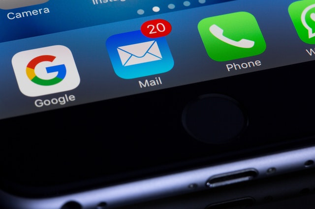 Iconos de aplicaciones en un teléfono móvil con notificaciones de correo electrónico.