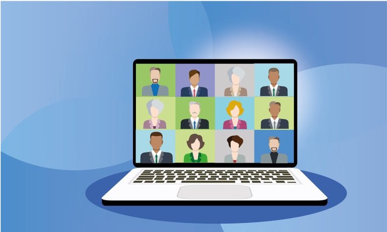 Reunión virtual con múltiples participantes en una laptop sobre fondo azul.